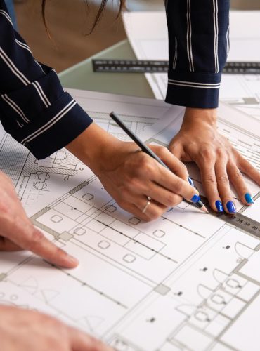 close up with hands two architects who draw something house plan blueprints new construction plan